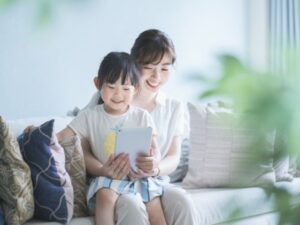 一緒にタブレットを見る親子